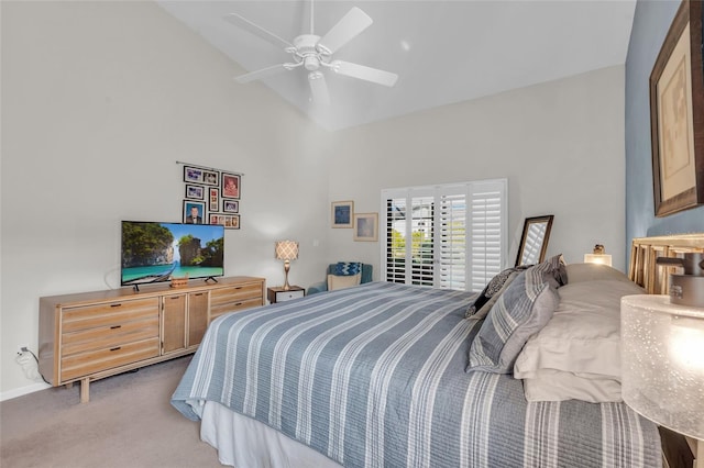 carpeted bedroom with ceiling fan and high vaulted ceiling