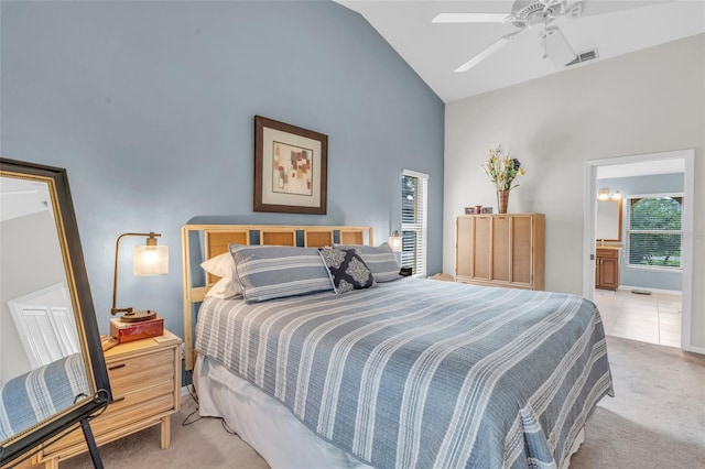 bedroom featuring high vaulted ceiling, ceiling fan, light colored carpet, and connected bathroom