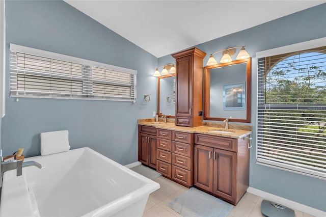 bathroom with tile patterned flooring, vanity, a tub to relax in, and lofted ceiling