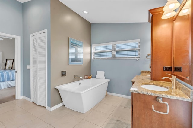 bathroom featuring tile patterned floors, vanity, a bathing tub, and vaulted ceiling