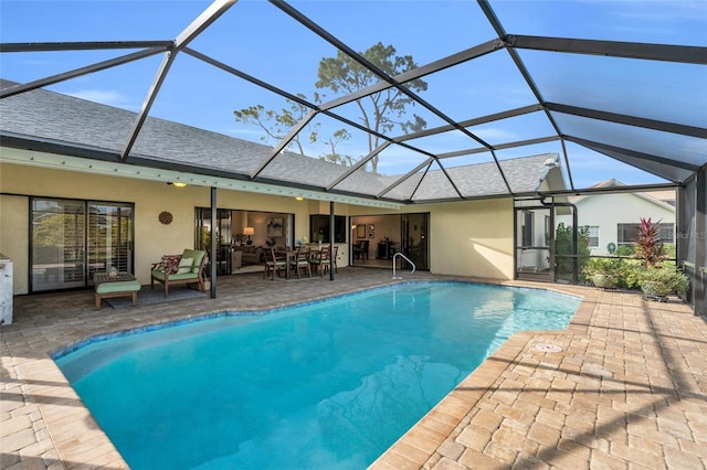 view of pool featuring glass enclosure and a patio