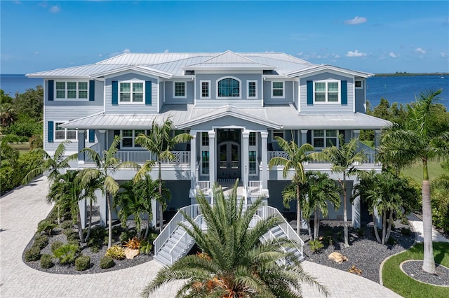 view of front of home featuring a porch, a water view, and french doors