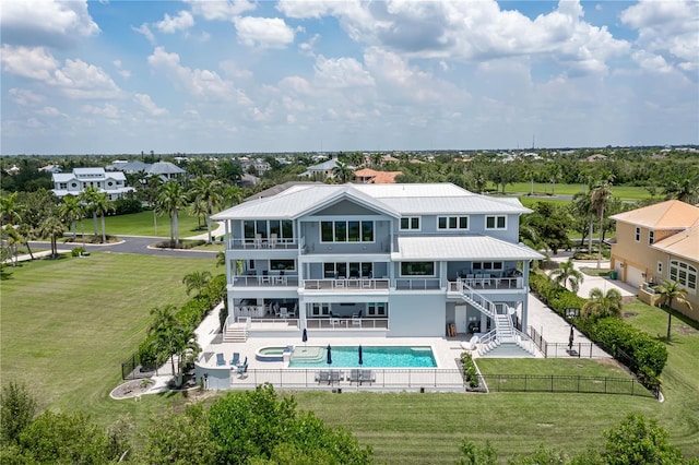 back of house with a fenced in pool, a balcony, a patio, and a yard