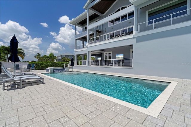 view of swimming pool featuring a patio area and an in ground hot tub