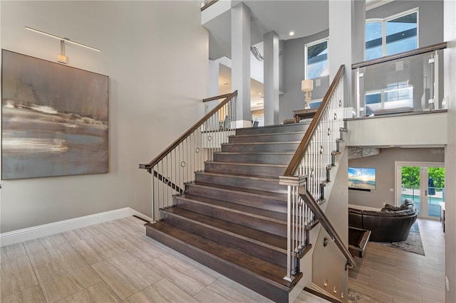 staircase featuring a towering ceiling