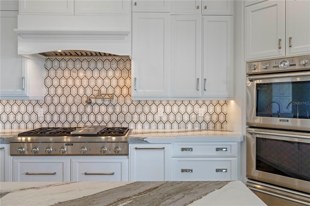 kitchen with white cabinets, light stone countertops, and appliances with stainless steel finishes