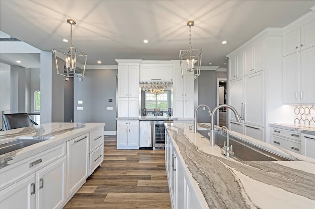 kitchen with white cabinetry, dark wood-type flooring, beverage cooler, crown molding, and pendant lighting