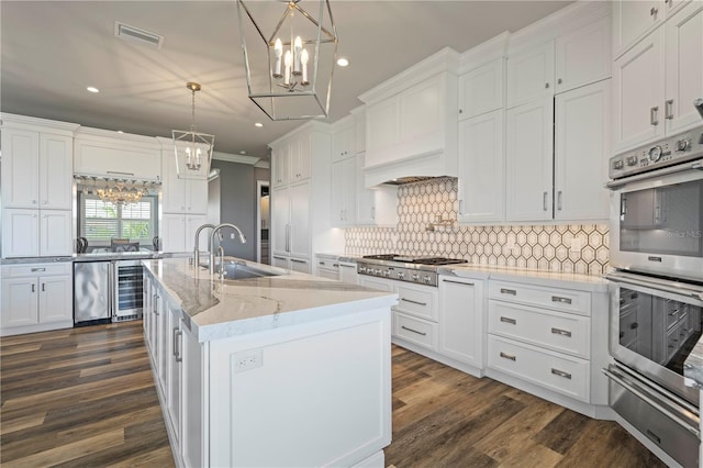 kitchen featuring decorative light fixtures, white cabinetry, sink, and stainless steel appliances