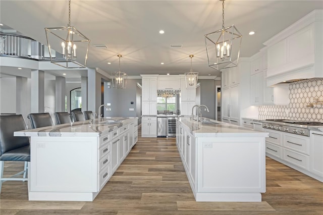 kitchen with a large island with sink and hanging light fixtures