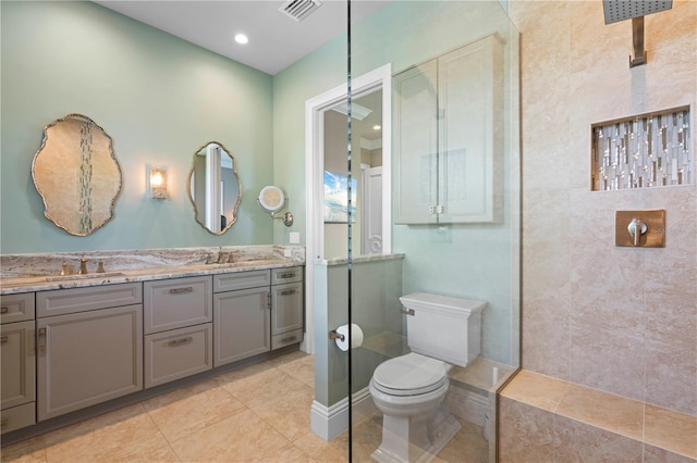 bathroom featuring tile patterned flooring, vanity, toilet, and walk in shower