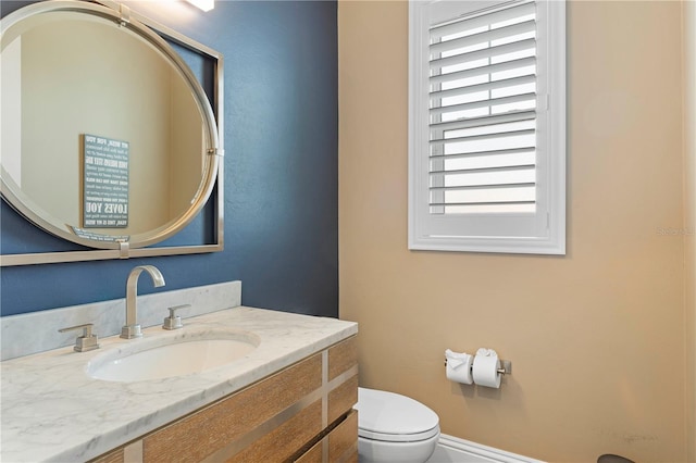 bathroom with vanity, toilet, and a wealth of natural light