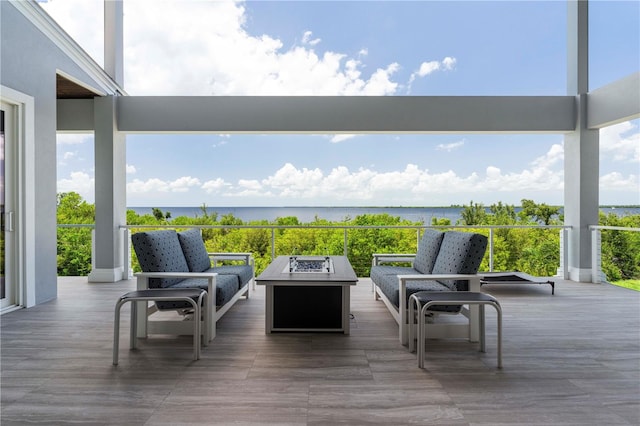 wooden deck with a water view and a fire pit