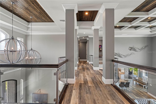 hallway with a wealth of natural light, dark hardwood / wood-style flooring, crown molding, and coffered ceiling