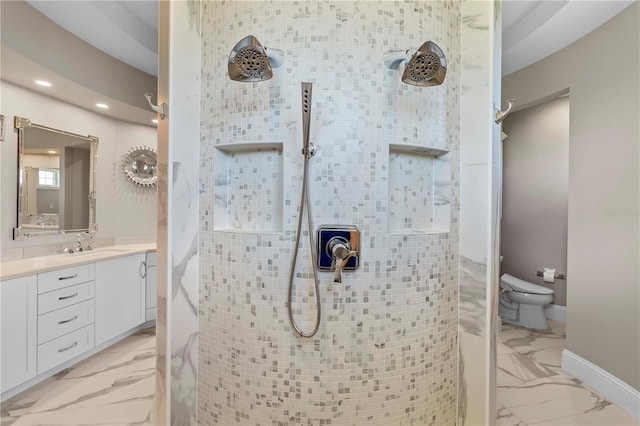 bathroom featuring tiled shower, vanity, and toilet