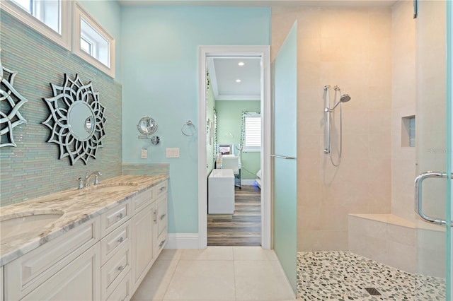 bathroom featuring tile patterned flooring, vanity, a shower with shower door, and ornamental molding