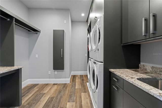 washroom featuring stacked washer / dryer and light wood-type flooring