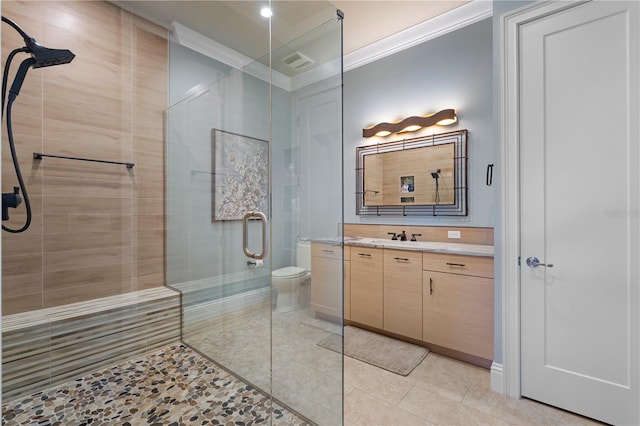 bathroom with vanity, tile patterned floors, toilet, ornamental molding, and walk in shower