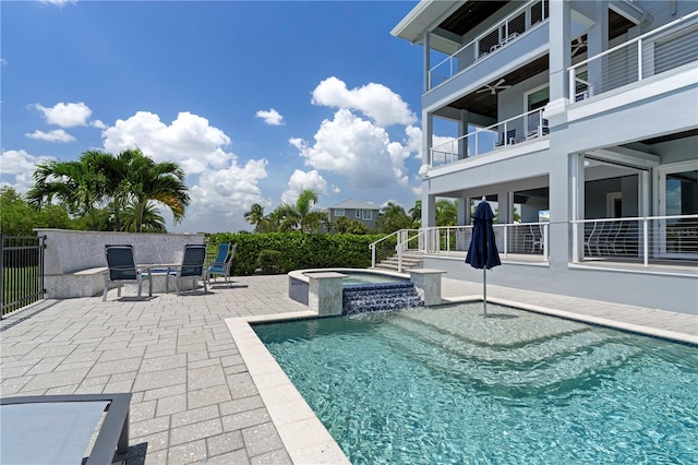 view of swimming pool featuring an in ground hot tub, pool water feature, and a patio