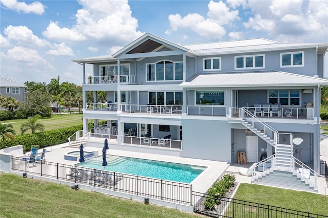 rear view of house featuring a swimming pool with hot tub and a patio area