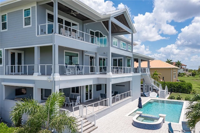 rear view of house featuring a patio, ceiling fan, and a pool with hot tub