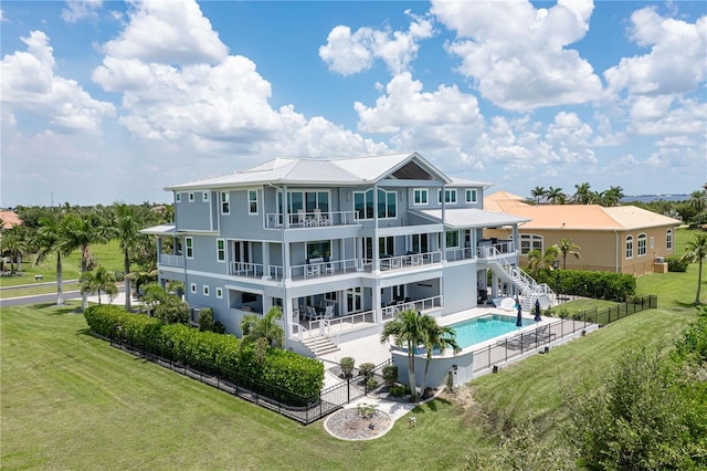 back of property with a fenced in pool, a yard, a balcony, and a patio