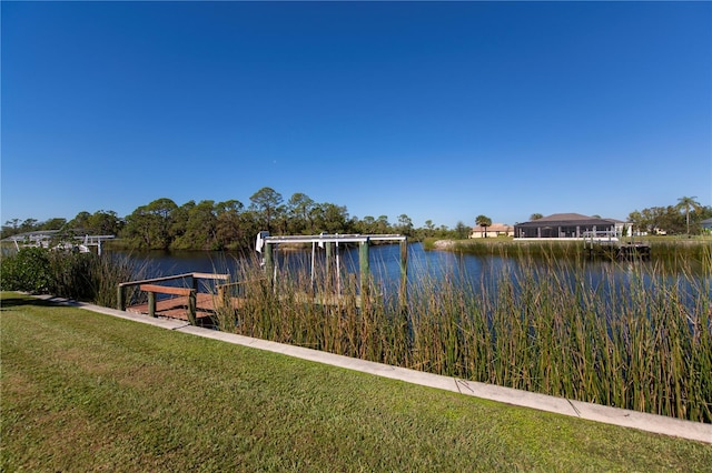 dock area featuring a water view and a lawn