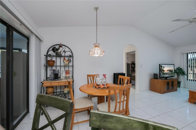 dining space featuring ceiling fan, light tile patterned floors, and vaulted ceiling