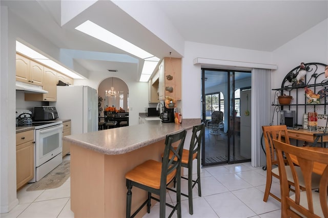 kitchen featuring an inviting chandelier, kitchen peninsula, white appliances, a breakfast bar, and light tile patterned floors