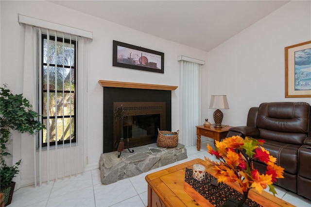 living room with a stone fireplace, light tile patterned floors, and lofted ceiling