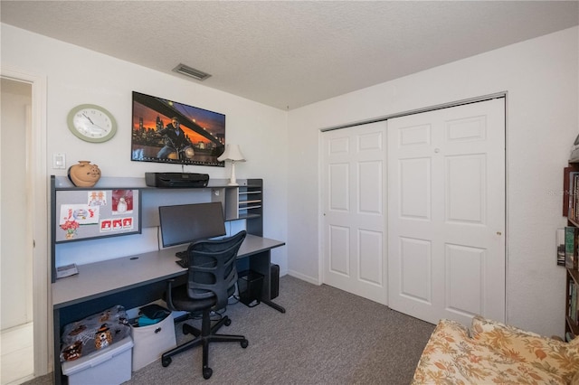 carpeted home office with a textured ceiling