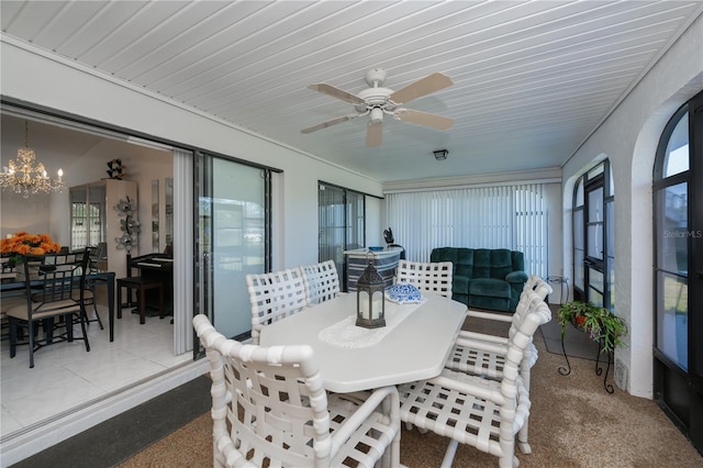 sunroom / solarium with ceiling fan with notable chandelier