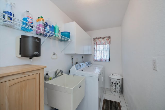 laundry room featuring washing machine and clothes dryer, sink, cabinets, and tile patterned flooring