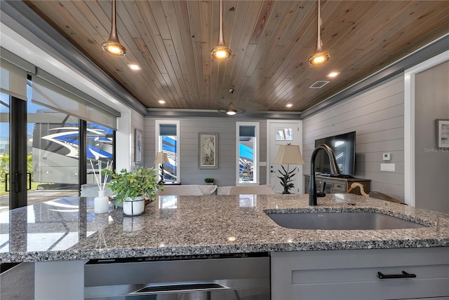 kitchen with white cabinets, decorative light fixtures, wood walls, and wooden ceiling