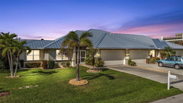 view of front of home with a garage and a yard