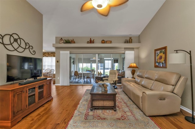 living room with ceiling fan, light hardwood / wood-style flooring, a healthy amount of sunlight, and lofted ceiling