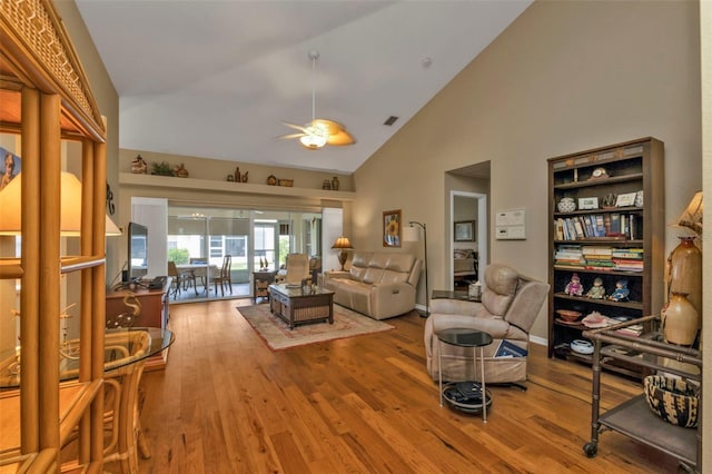 living room featuring hardwood / wood-style floors, ceiling fan, and high vaulted ceiling