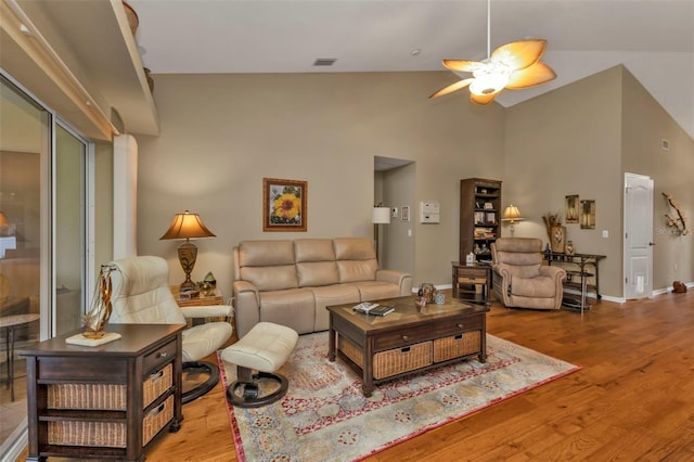 living room featuring ceiling fan, high vaulted ceiling, and light hardwood / wood-style floors