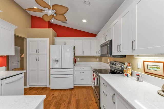 kitchen featuring white cabinets, stainless steel appliances, light hardwood / wood-style flooring, and lofted ceiling