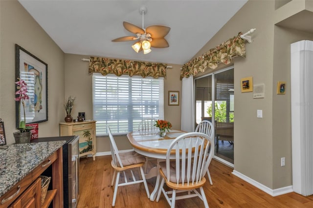 dining room with a wealth of natural light, ceiling fan, light hardwood / wood-style floors, and lofted ceiling