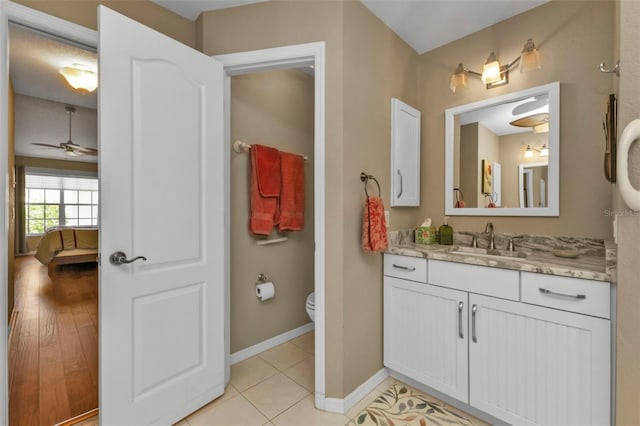 bathroom featuring ceiling fan, toilet, vanity, and hardwood / wood-style flooring