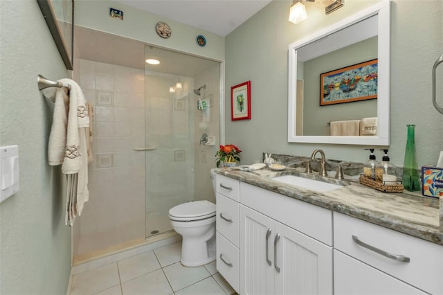 bathroom featuring tile patterned floors, vanity, toilet, and tiled shower