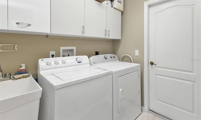 laundry area featuring washer and clothes dryer, light tile patterned flooring, cabinets, and sink