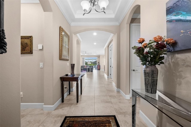 hall featuring a chandelier, light tile patterned floors, and ornamental molding