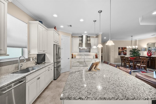 kitchen with a spacious island, sink, stainless steel appliances, and wall chimney range hood