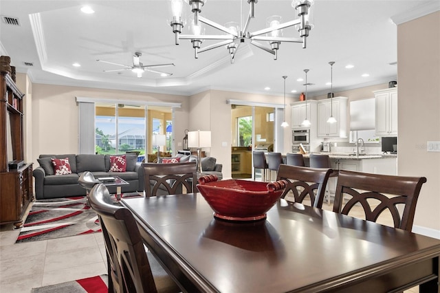 dining area featuring a tray ceiling, a wealth of natural light, and ornamental molding