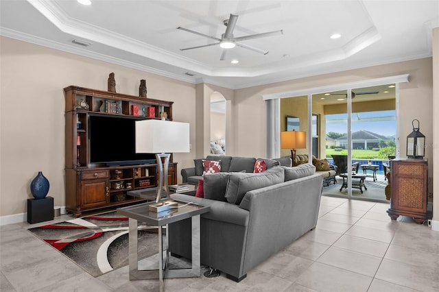 tiled living room with ceiling fan, crown molding, and a tray ceiling