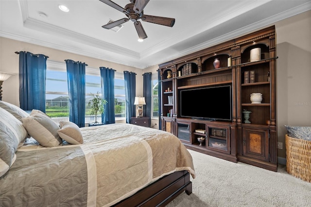 bedroom with a raised ceiling, ceiling fan, carpet floors, and ornamental molding