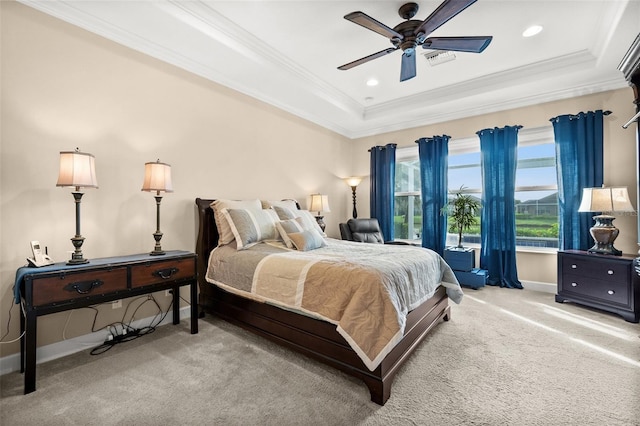 carpeted bedroom featuring ceiling fan, ornamental molding, and a tray ceiling