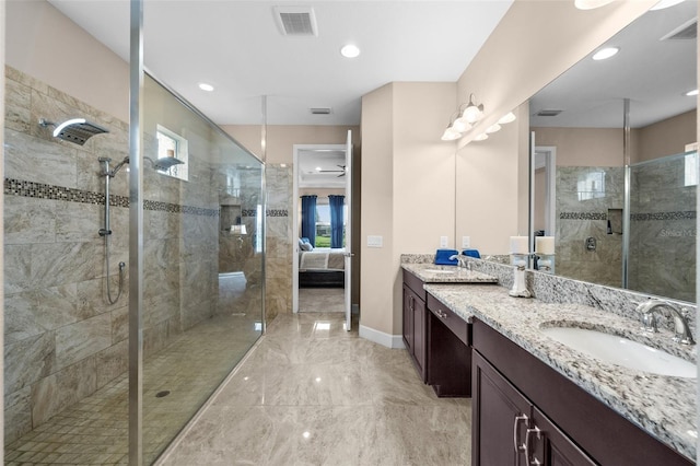 bathroom with tiled shower, vanity, and plenty of natural light