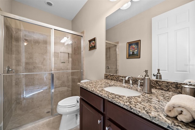 bathroom with vanity, a shower with shower door, and toilet